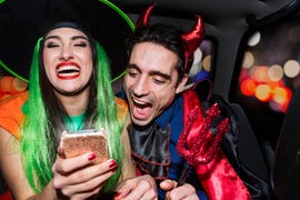 halloween witch and devil laughing in back of car