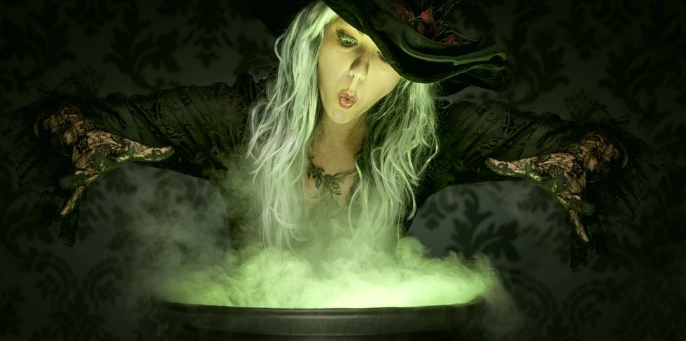women dressed as witch over cauldron