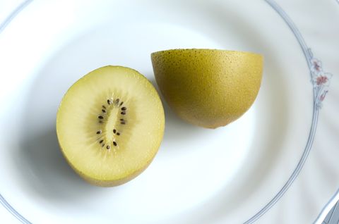 halved golden kiwi kiwi sungold on white plate
