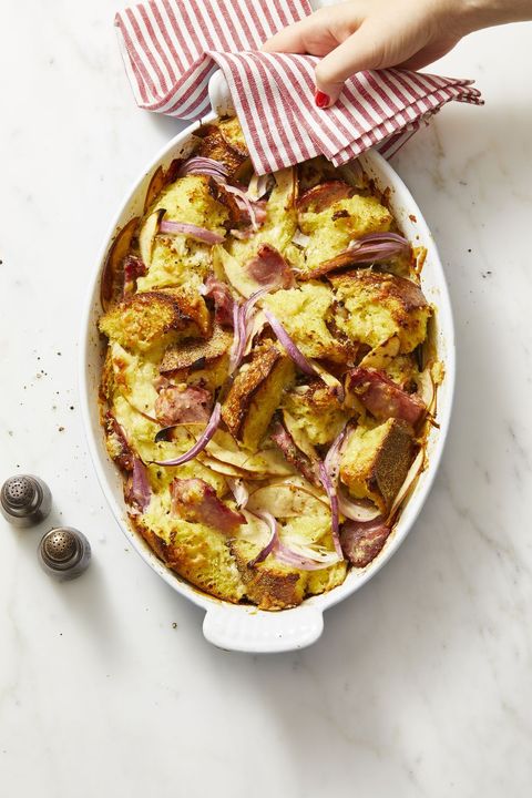 ham, cheddar, and red onion bread pudding in a white baking dish