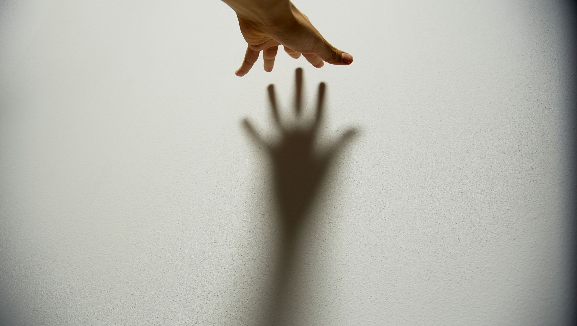 hand against a wall casting a shadow