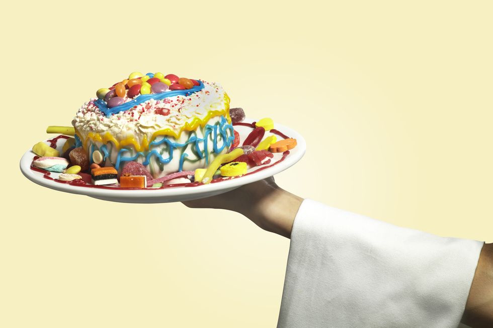 hand holding a colorful messy home made cake