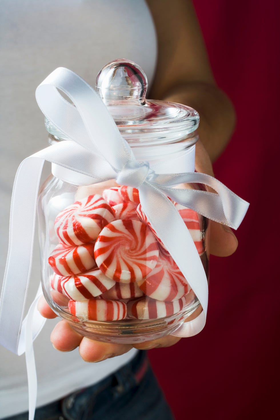 hand holding a jar of peppermint candies