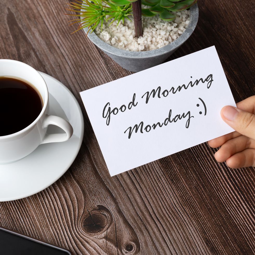 hand holding a piece of paper with good morning monday greeting