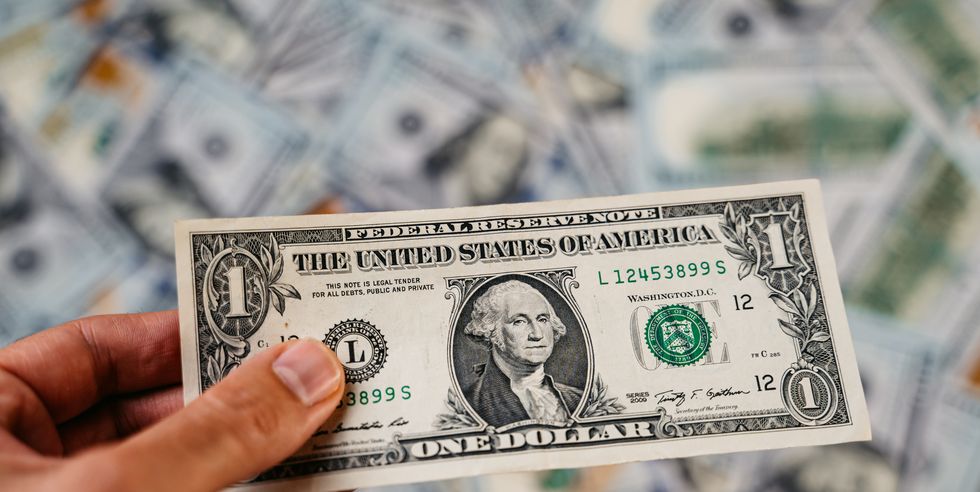 hand holding american one dollar bill featuring a portrait of george washington