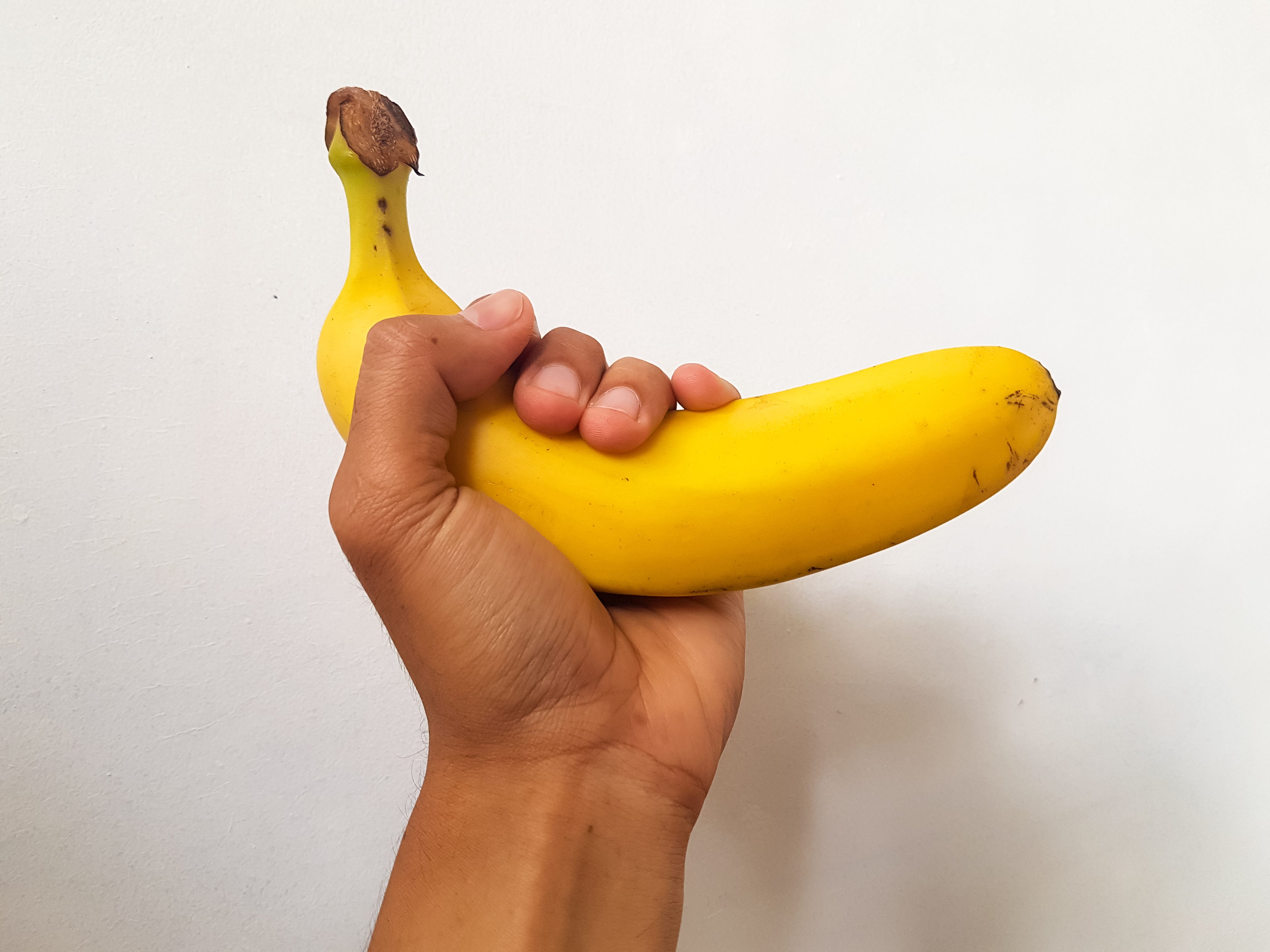 hand holding big banana on white background