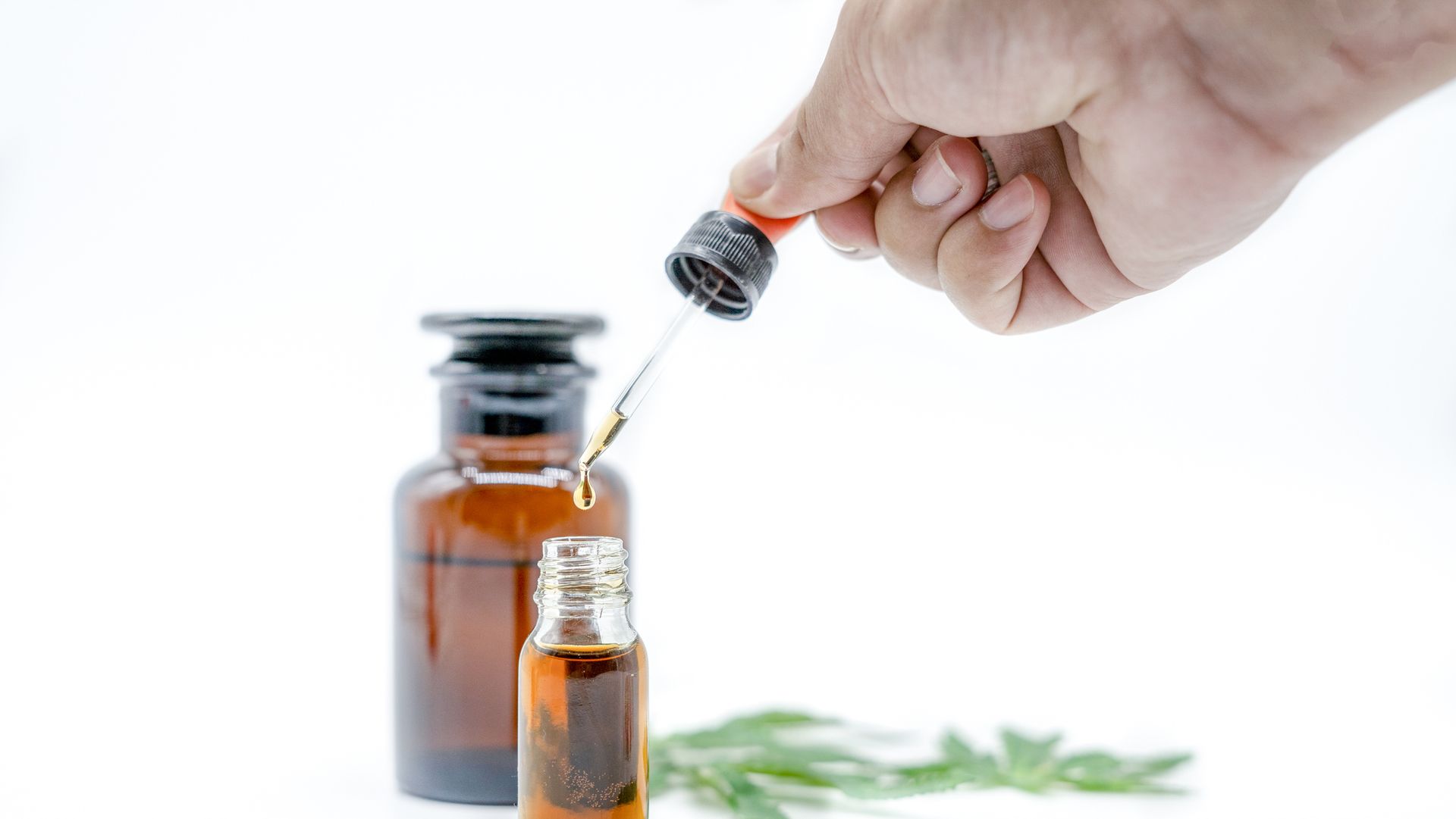 Hand holding bottle of Cannabis oil in, natural herb, medical marijuana concept, CBD cannabis OIL. hemp product, close up,