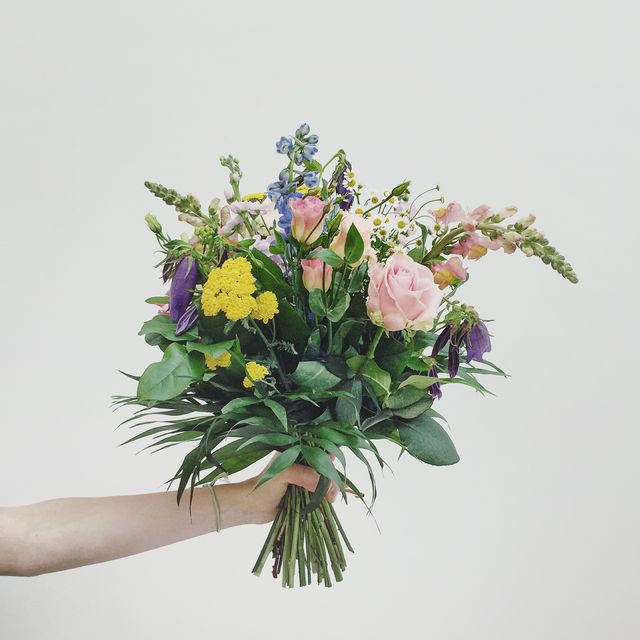 hand holding bouquet of flowers the surprising meaning behind flowers
