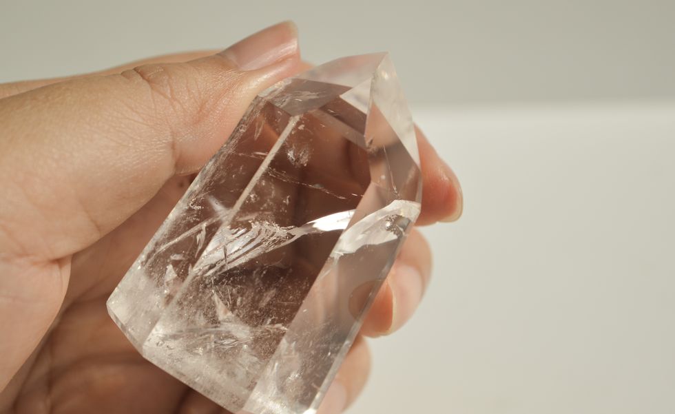 hand holding clear quartz crystal