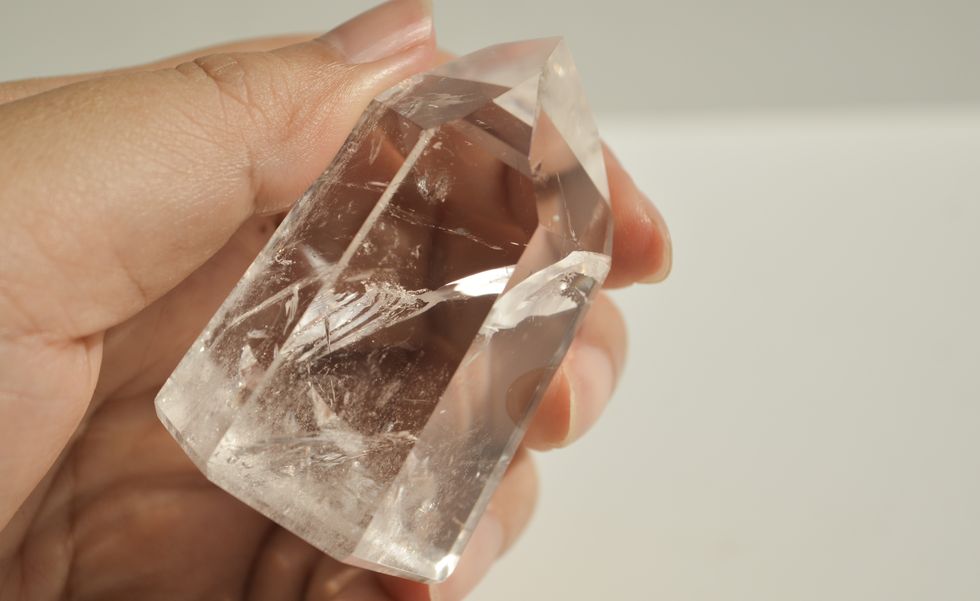 hand holding clear quartz crystal