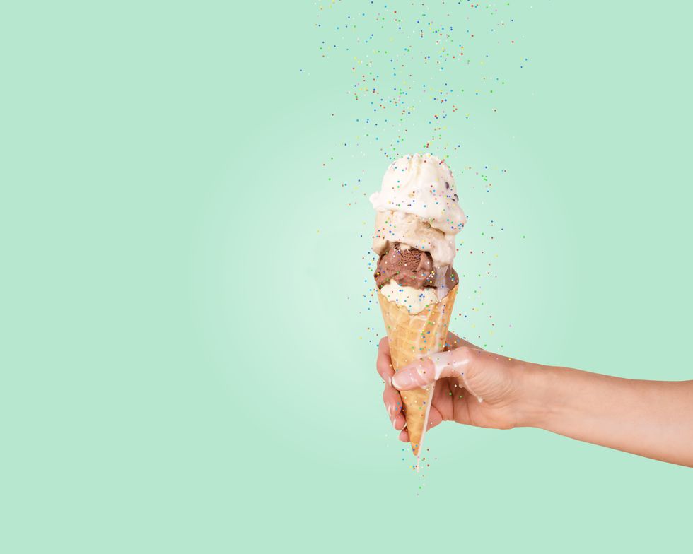 hand holding ice cream cone with sprinkles