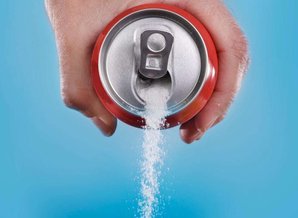 hand holding soda can pouring in metaphor of sugar content