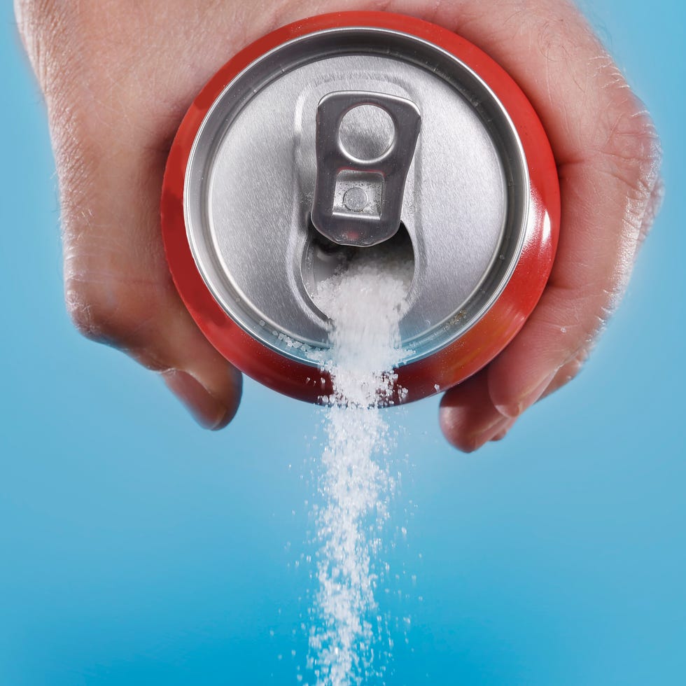 hand holding soda can pouring in metaphor of sugar content hand holding soda can pouring in metaphor of sugar content