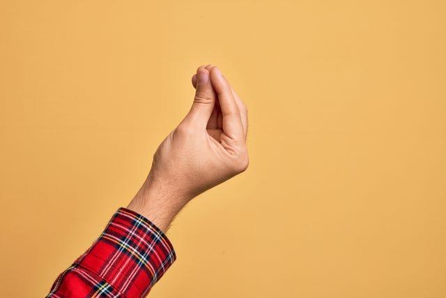 hand of caucasian young man showing fingers over isolated yellow background doing italian gesture with fingers together, communication gesture movement