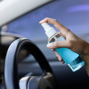hand of driver is spraying alcohol,disinfectant spray in car,safety,prevent infection of covid 19 virus,coronavirus, contamination of germs or bacteria alcohol sanitizer,hygiene concept