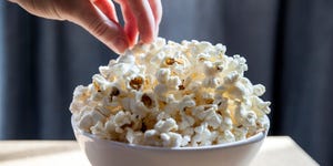 hand picking freshly made popcorn from the bowl