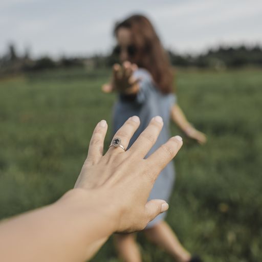 Hand reaching out for woman on a field