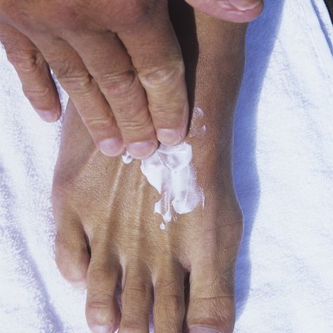 Hand rubbing lotion on foot