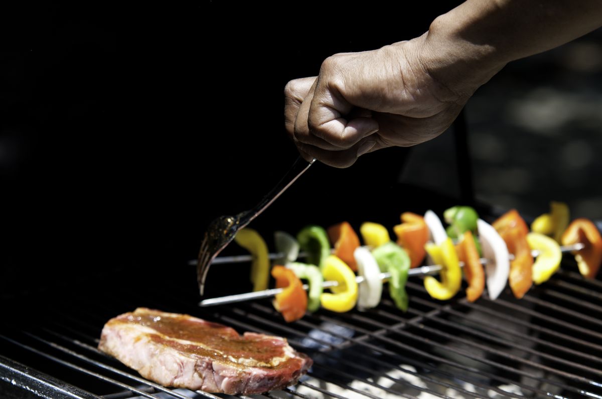 hand turning food on a grill