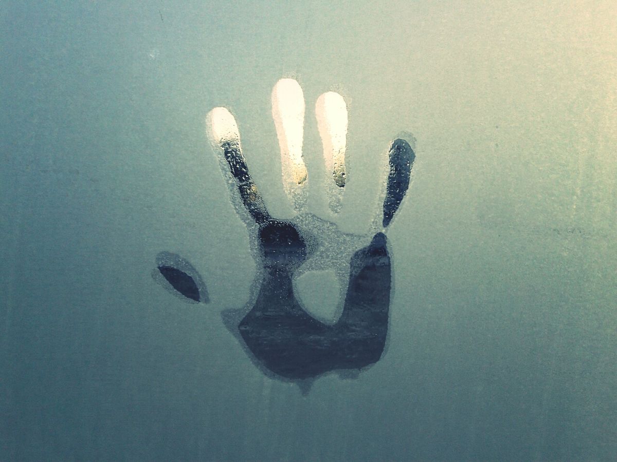 handprint on condensed glass window