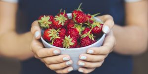 Hands holding bowl of strawberries
