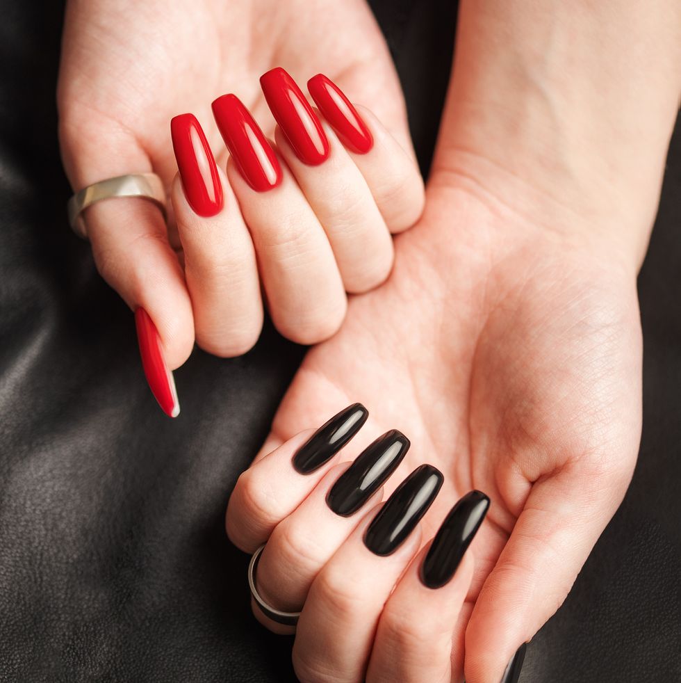 hands of a young girl with black and red manicure on nails