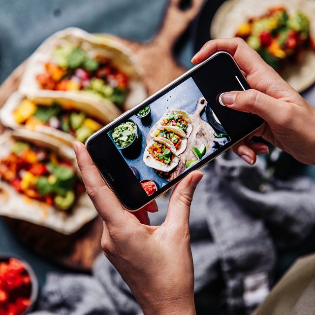 hands of cook photographing mexican tacos
