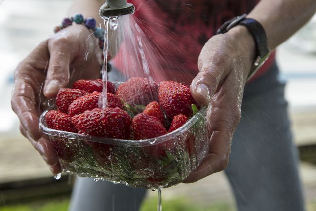 persona lavando unas fresas