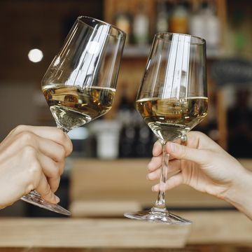 hands of women toasting with glasses of white wine