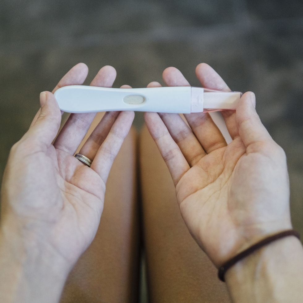 Hands of young girl holding a pregnancy test