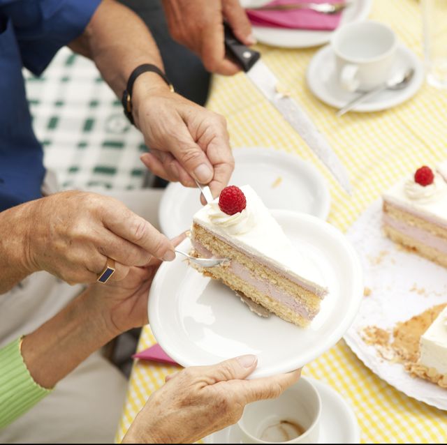 Hands putting cream cake on plates