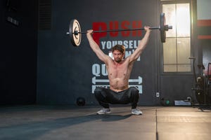 handsome and muscular white male doing press weightlifting in a gym