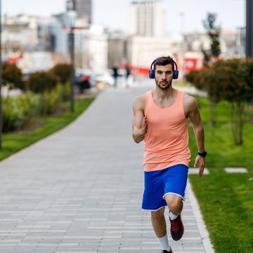 handsome athlete is running through the city