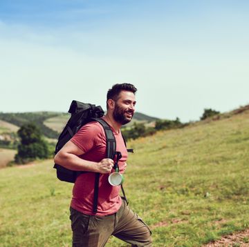 handsome smiling latino male enjoying nature during hiking
