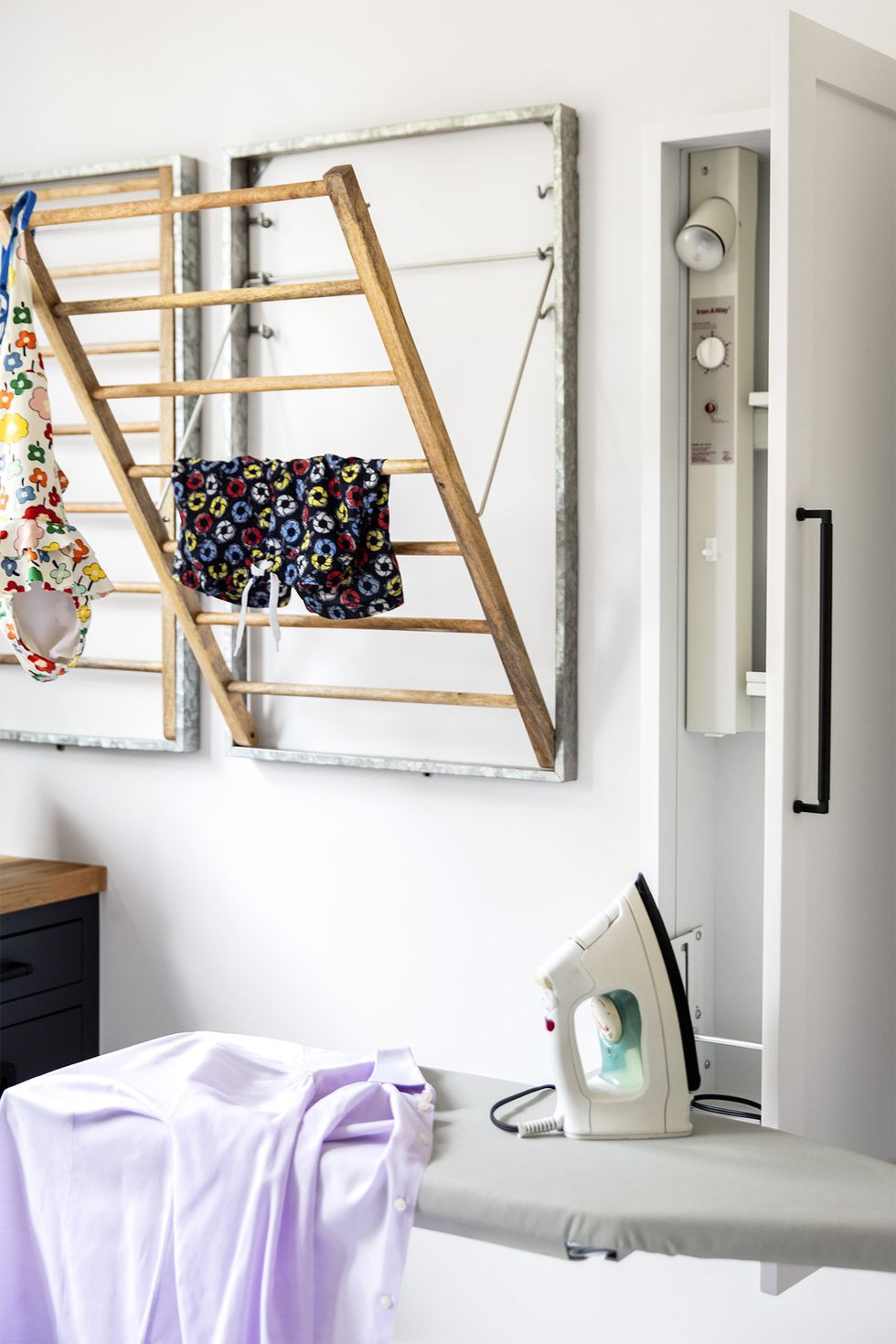 laundry room with drying racks, ironing board designed by emilie munroe, studio munroe