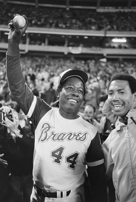 original caption atlanta hank aaron holds up the ball that broke babe ruth's home run record apr 8th aaron hit the ball over the wall for the 715th record breaking home run in the fourth inning off dodger pitcher al downing with aaron is his personal bodyguard, calvin wardlow 481974