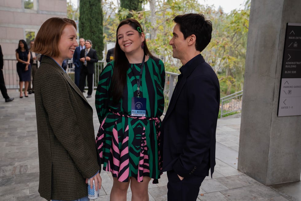 three people stand together speaking
