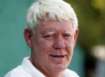 portrait of an older person with white hair against a blurred background