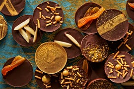 chocolate coins with various toppings of nuts and dried fruit