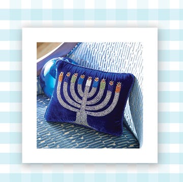 a blue throw pillow with an embroidered menorah and a photo of a set of three hanukkah themed dish cloths on a blue and white background