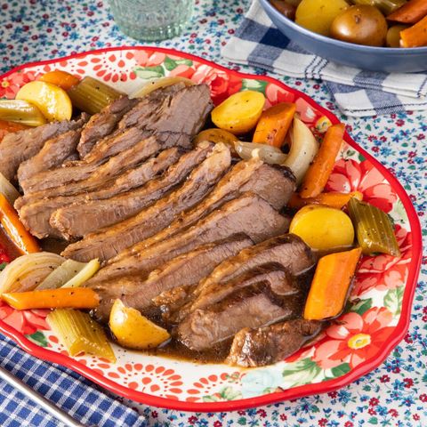 slow cooker brisket on red floral plate with veggies
