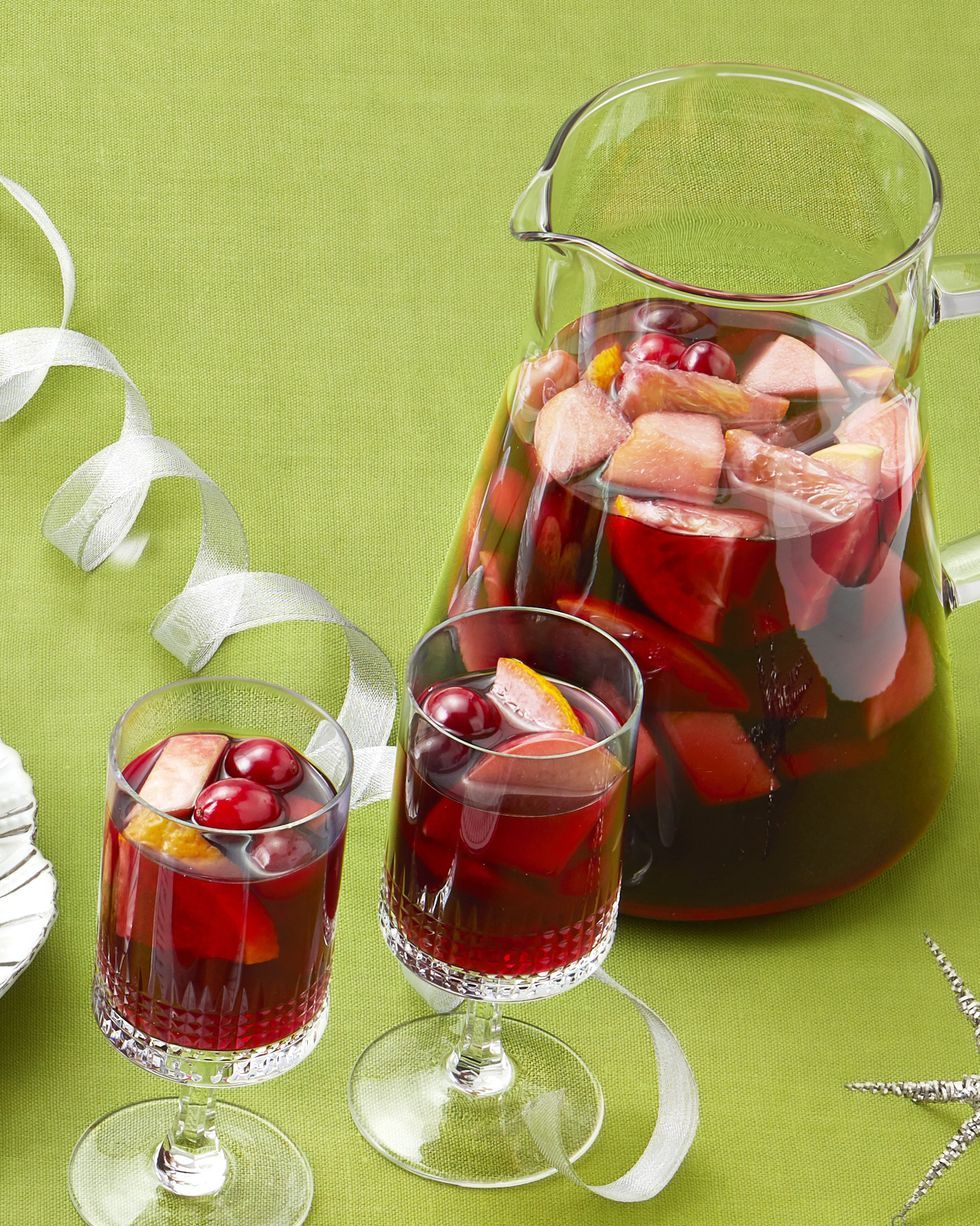winter sangria in pitcher and glasses green background