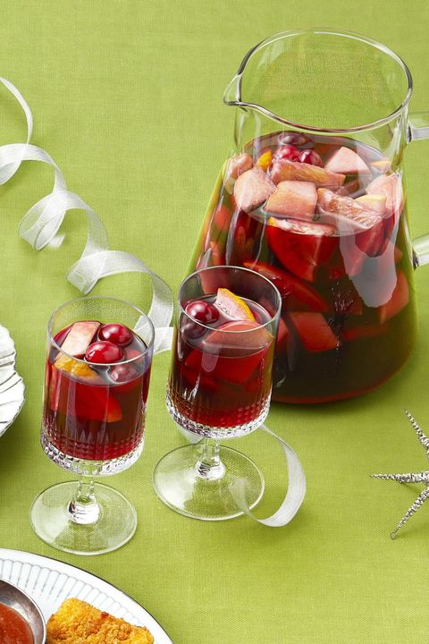 winter sangria in pitcher and glasses green background