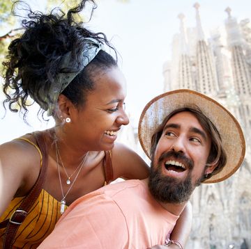 a justmarried couple taking a selfie with the sagrada familia in the background