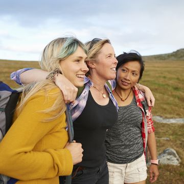 happy and positive hiking friends huddle together on a rocky moorland