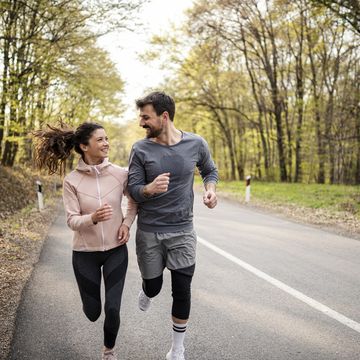 happy athletic couple having fun while running in spring day