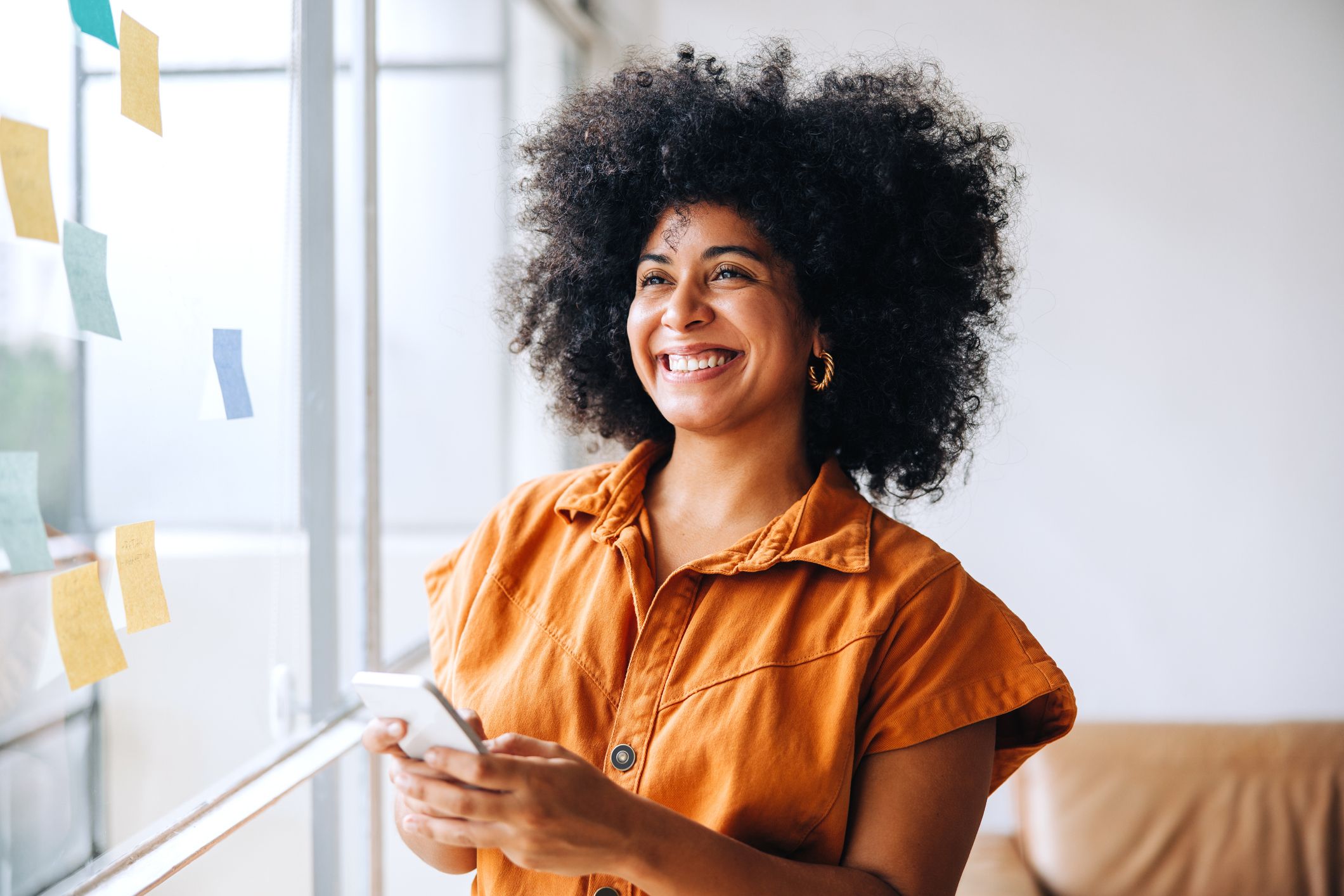 happy black businesswoman using a smartphone in a creative office