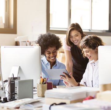 happy businesswomen using digital tablet in office