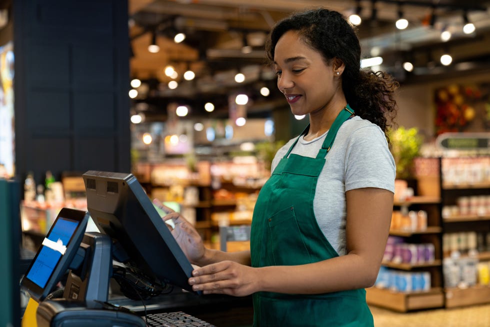 happy cashier working on the cash register at the supermarket