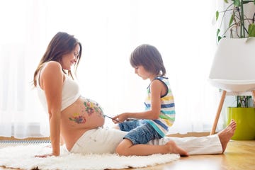 happy child, boy, painting on mommy's pregnant belly